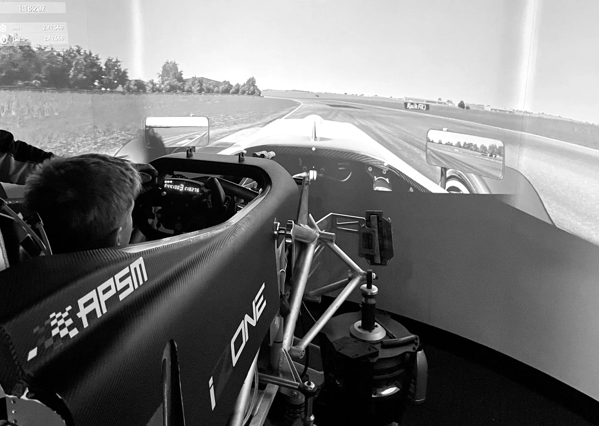 young boy in a full size race car simulator