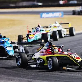 group of single seater racing cars flowing through a corner
