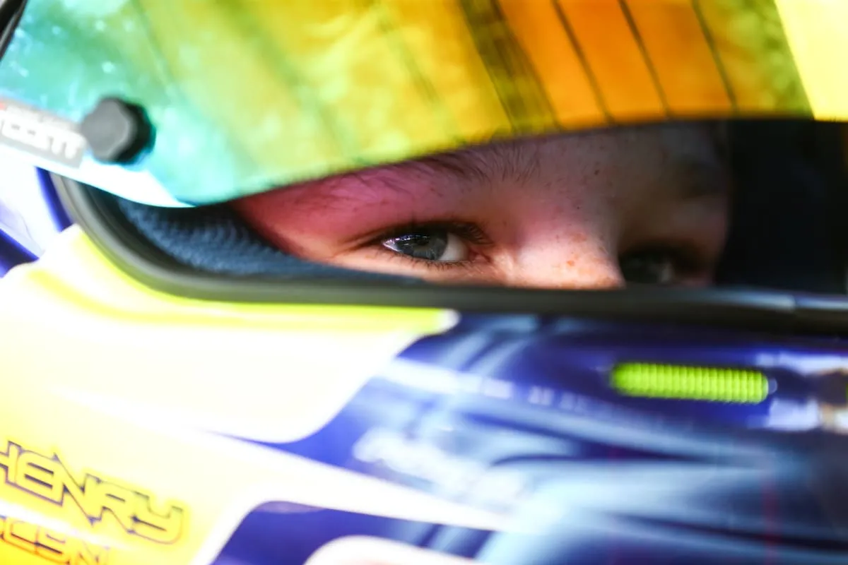 close up of the concentration in a young racing driver's eyes through the raised visor of his helmet